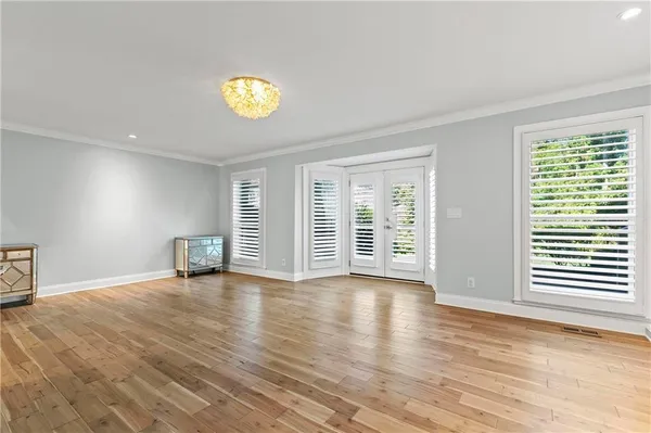 an empty room with windows and wooden floor
