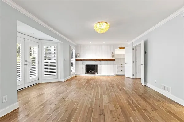an empty room with wooden floor and fireplace