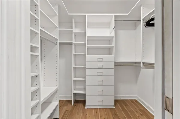 a view of walk in closet with empty racks