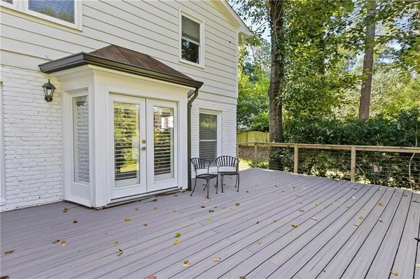a balcony with wooden floor table and chairs