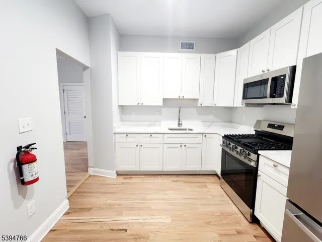 a kitchen with granite countertop white cabinets and appliances