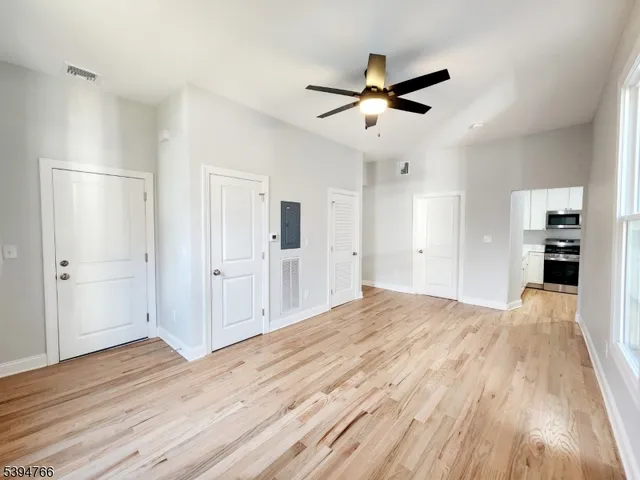 a view of a livingroom with wooden floor and a ceiling fan