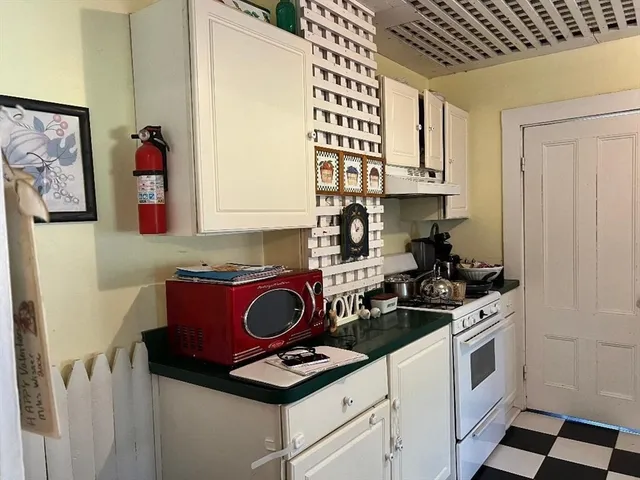 a kitchen with a stove and a white cabinet