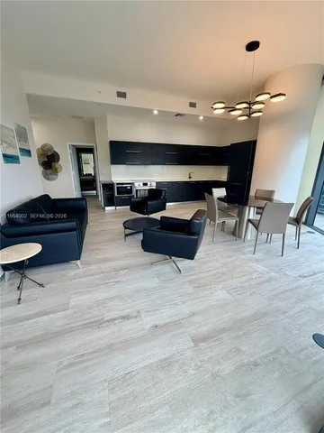 a living room with furniture a flat screen tv and a large window