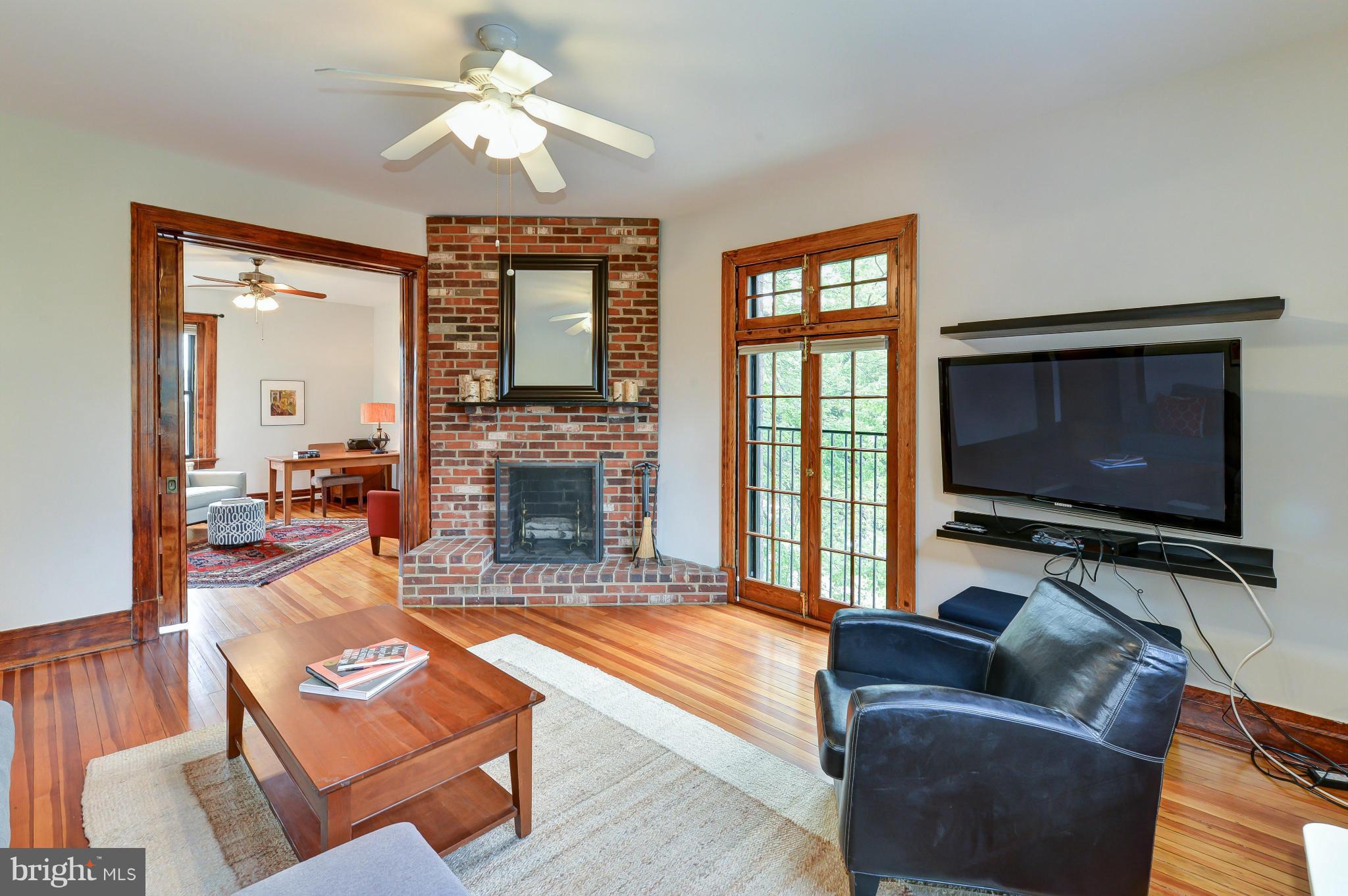 2852 Ontario Road Northwest, Unit 22 Washington, DC 20009 - Photo 2 of 30 a living room with furniture a flat screen tv and a fireplace
