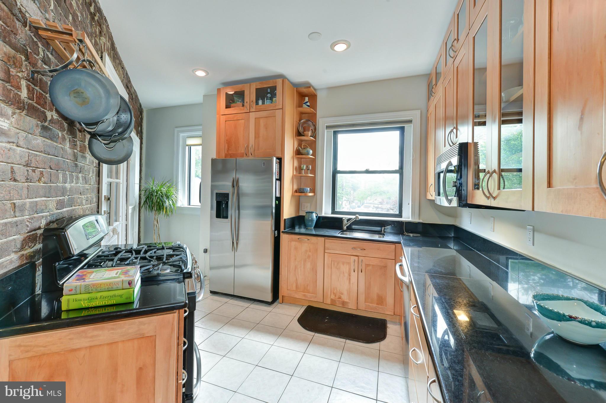 2852 Ontario Road Northwest, Unit 22 Washington, DC 20009 - Photo 15 of 30 a kitchen with stainless steel appliances granite countertop a stove a sink and a granite counter tops