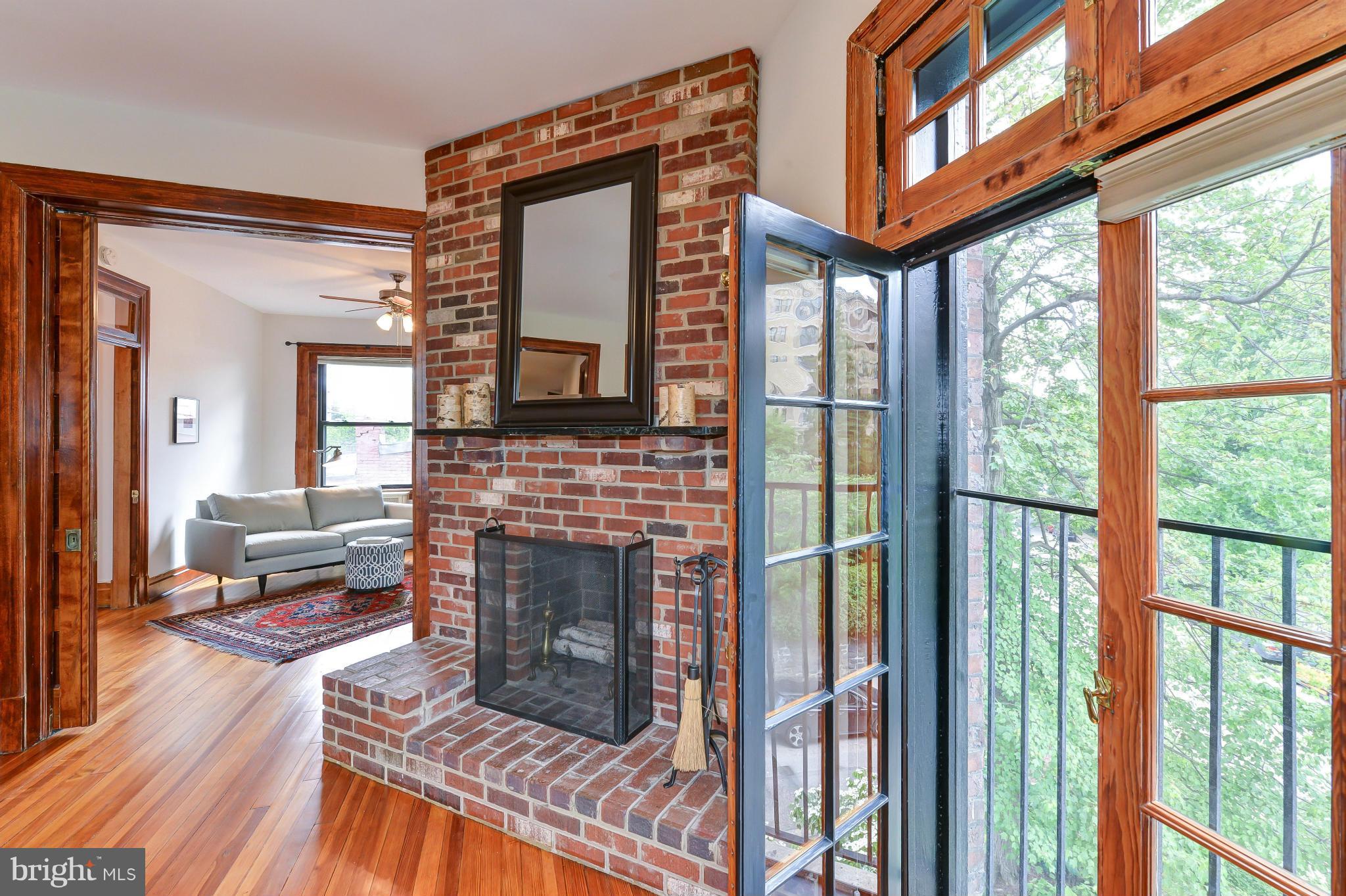2852 Ontario Road Northwest, Unit 22 Washington, DC 20009 - Photo 4 of 30 a living room with furniture a fireplace and a floor to ceiling window