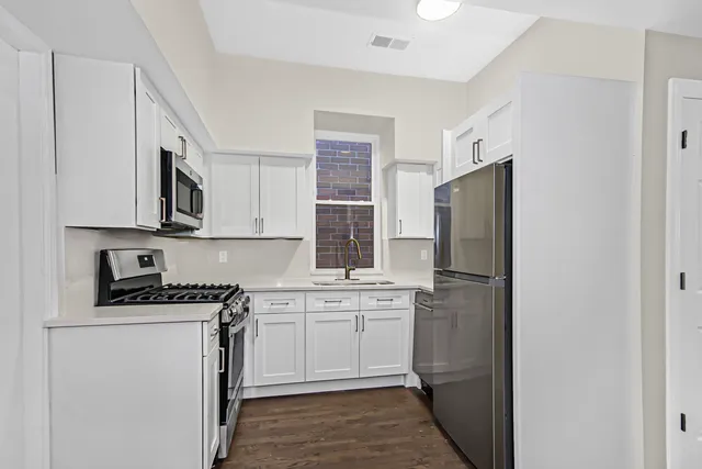 a kitchen with a sink a refrigerator and cabinets