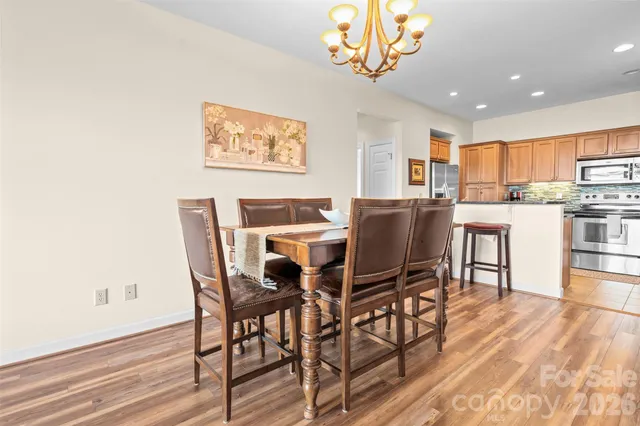 a view of a dining room with furniture a chandelier and wooden floor