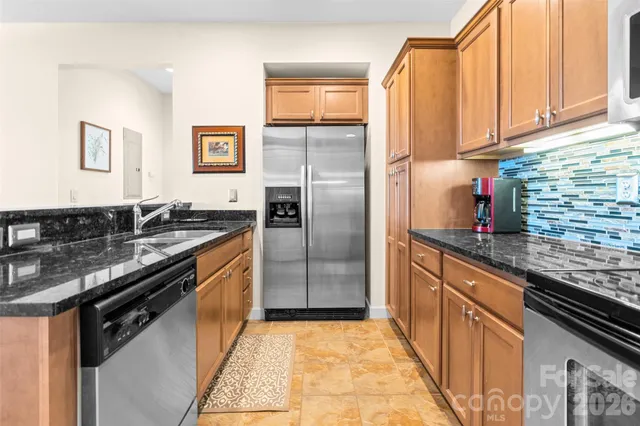 a kitchen with granite countertop stainless steel appliances and wooden cabinets