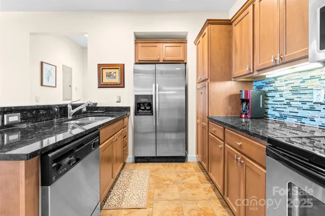 a kitchen with granite countertop stainless steel appliances and wooden cabinets