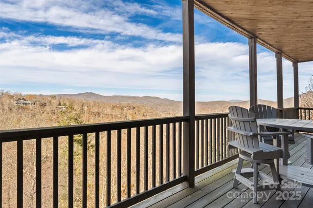a view of a balcony with wooden floor next to a yard