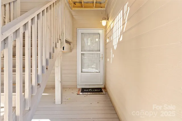 a view of a hallway with wooden floor and staircase