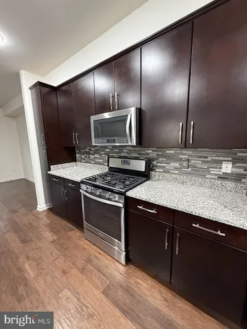 a view of a livingroom with wooden floor a chandelier and window