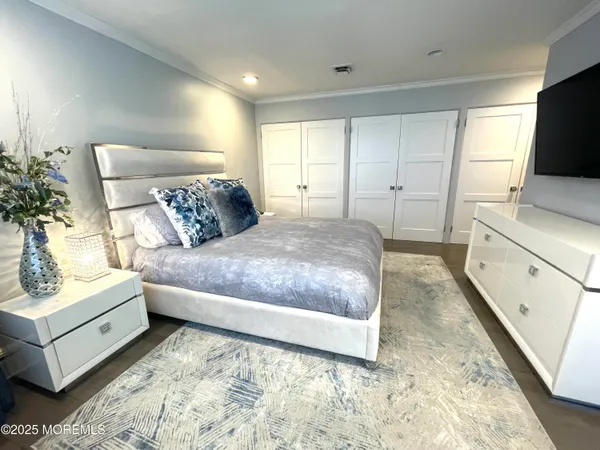 a spacious bedroom with a bed and a flat screen television