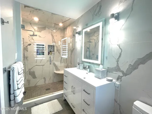 a bathroom with a double vanity sink mirror and shower
