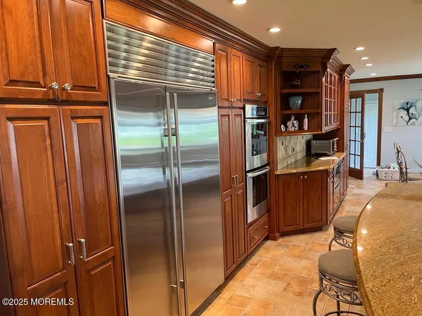 a kitchen with stainless steel appliances granite countertop a refrigerator and a sink