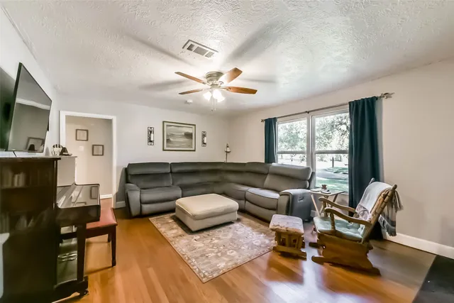 a living room with furniture and wooden floor