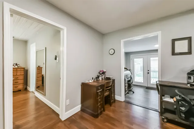 a kitchen with a refrigerator a stove and a dining table with wooden floor