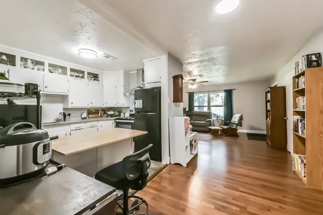 a kitchen with granite countertop a stove and a white cabinets