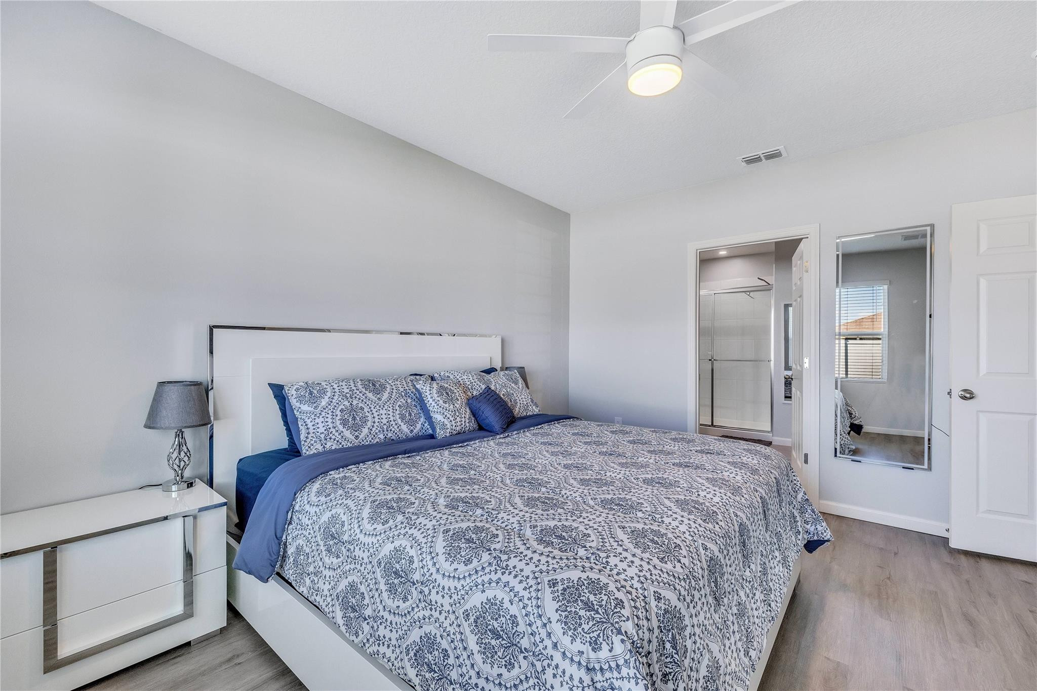 568 Southwest Undallo Road Port St. Lucie, FL 34953 - Photo 20 of 52 a bedroom with a large bed and a chandelier