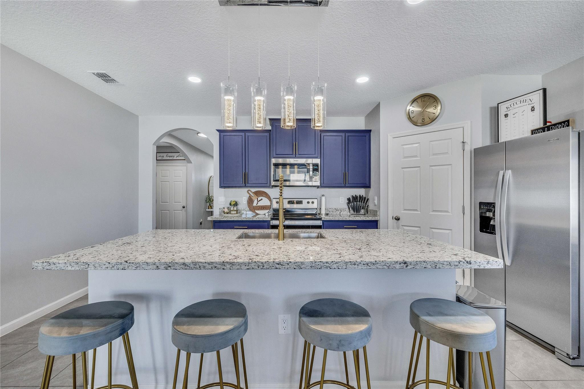 568 Southwest Undallo Road Port St. Lucie, FL 34953 - Photo 8 of 52 a kitchen with stainless steel appliances granite countertop a sink a stove a refrigerator and chairs