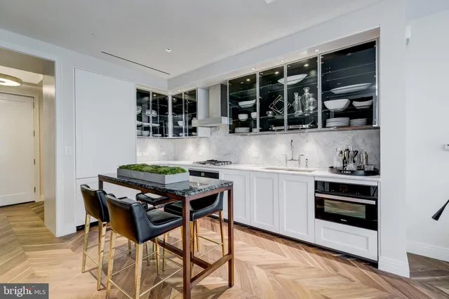 a kitchen with stainless steel appliances kitchen island granite countertop a stove and a view of living room