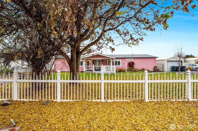 a view of a house with a small yard and wooden fence