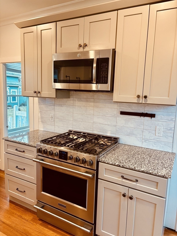163 West Central Street Franklin, MA 02038 - Photo 12 of 39 a kitchen with stainless steel appliances granite countertop white cabinets and a stove top oven