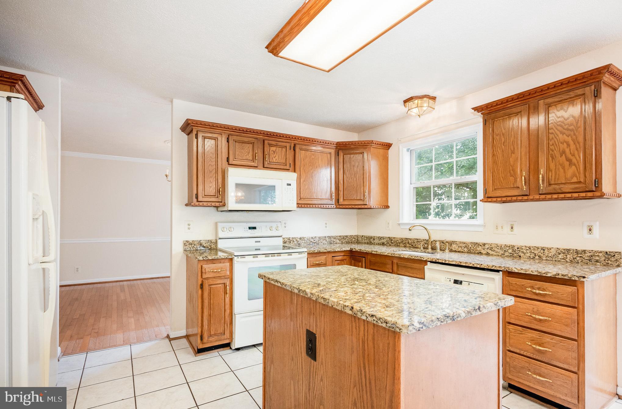 10402 Labrador Loop Manassas, VA 20112 - Photo 9 of 44 a kitchen with granite countertop a sink stove and cabinets