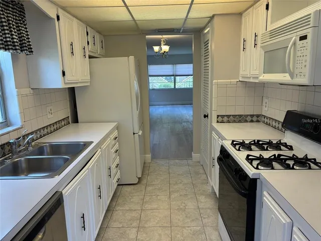 a kitchen with stainless steel appliances a stove a sink and a refrigerator