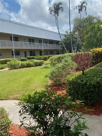 a front view of a house with a yard and potted plants