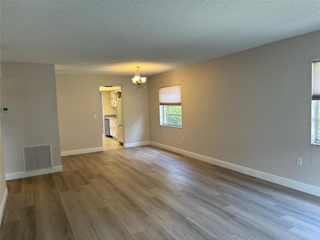 10033 64th Avenue North, Unit 1 St. Petersburg, FL 33708 - Photo 8 of 26 an empty room with wooden floor and windows
