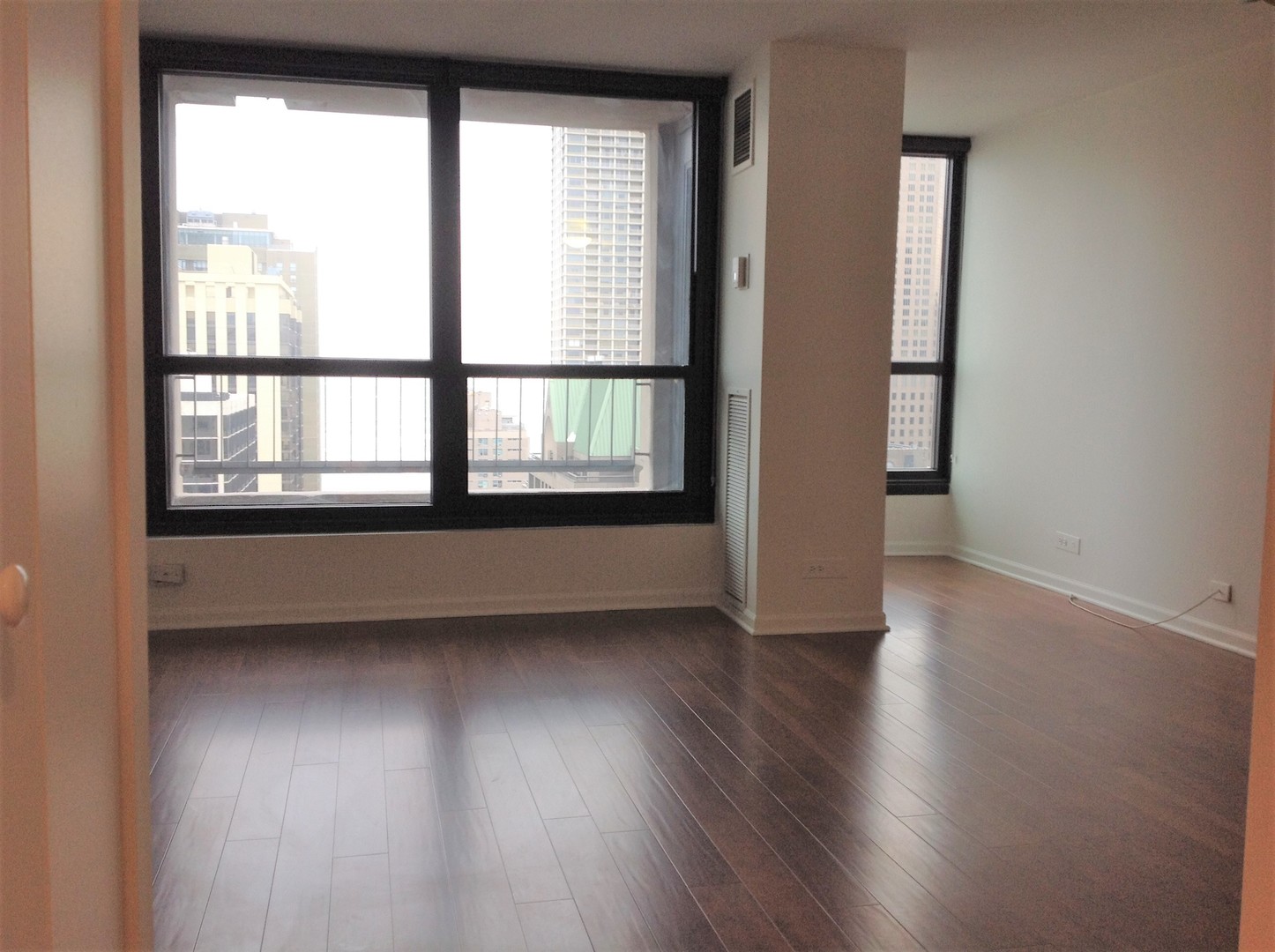 1030 North State Street, Unit 23F Chicago, IL 60610 - Photo 6 of 13 an empty room with wooden floor and windows