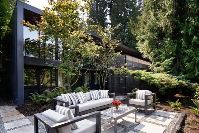 a view of a patio with table and chairs potted plants and a large tree