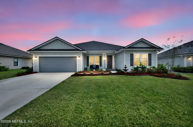 a front view of a house with yard and green space