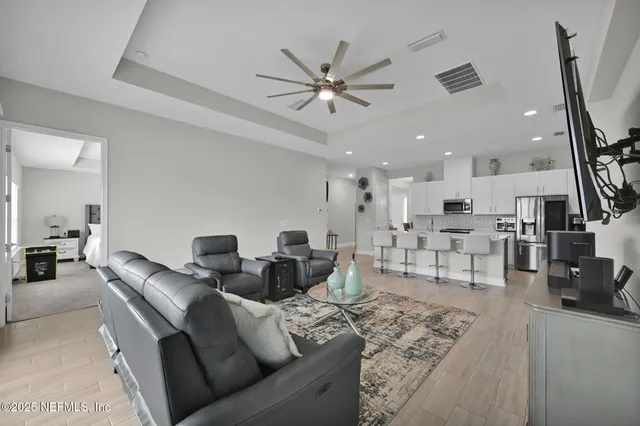 a living room with furniture and a view of kitchen