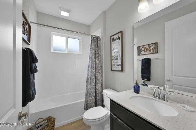 a bathroom with a granite countertop sink toilet a mirror a vanity and shower