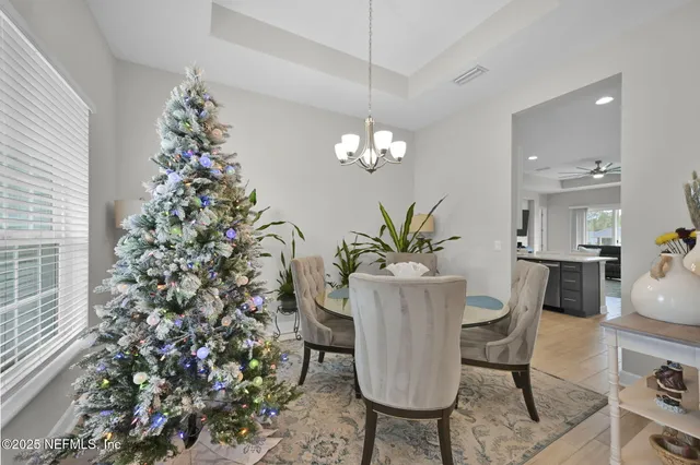 a view of a dining room with furniture and chandelier