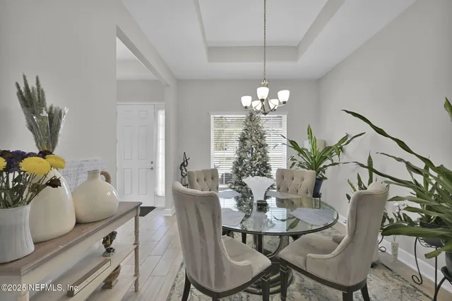 a dining room with furniture a chandelier and wooden floor