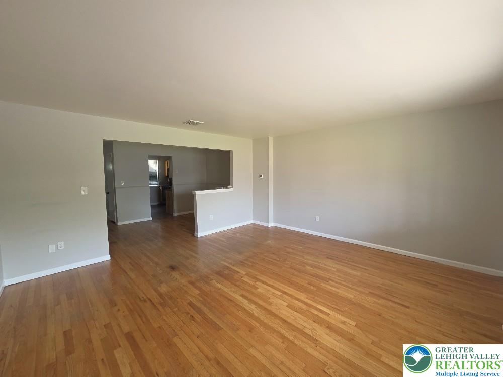 1747 Schoenersville Road Bethlehem, PA 18018 - Photo 3 of 13 Natural light illuminates this spacious living area, showcasing its polished hardwood floors.