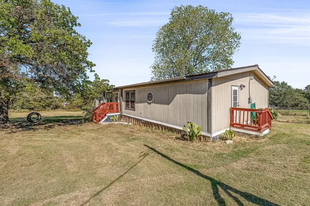 a view of a house with backyard and a tree