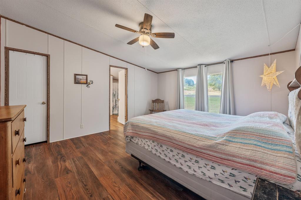 192 Big Salty Lane Springtown, TX 76082 - Photo 12 of 36 a bedroom with a bed and a ceiling fan