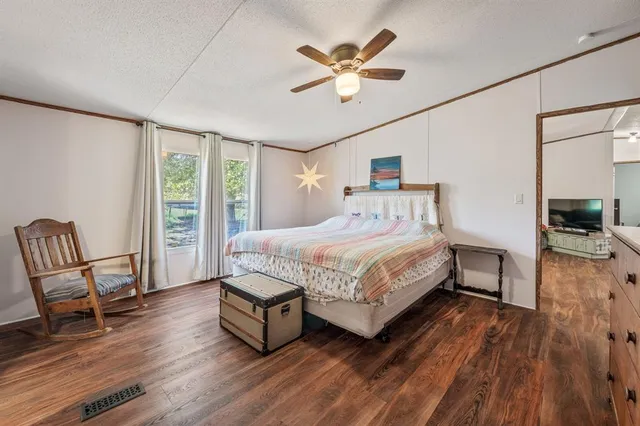 a bedroom with a bed a chair and a chandelier
