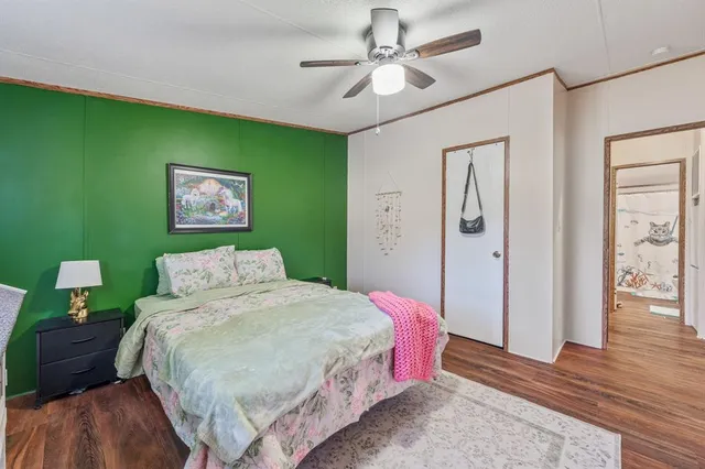a bedroom with a bed chandelier and a window