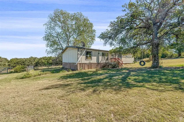 a front view of a house with a yard and trees
