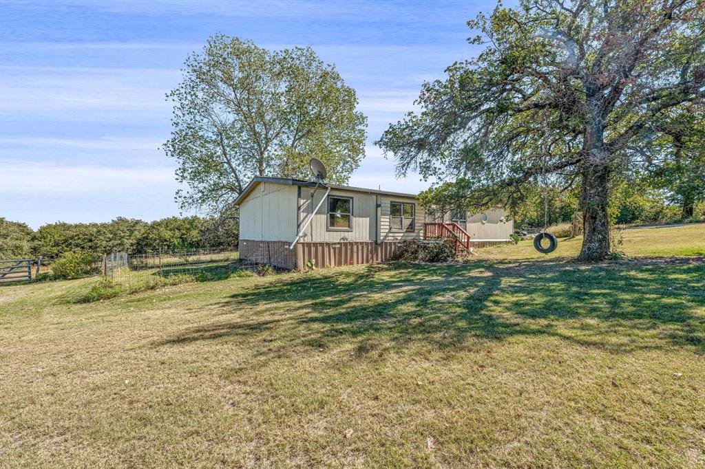 192 Big Salty Lane Springtown, TX 76082 - Photo 2 of 36 a front view of a house with a yard and trees