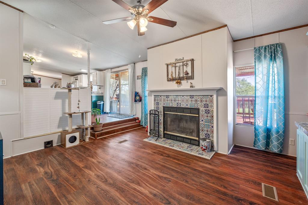 192 Big Salty Lane Springtown, TX 76082 - Photo 23 of 36 a living room with wooden floor and a fireplace