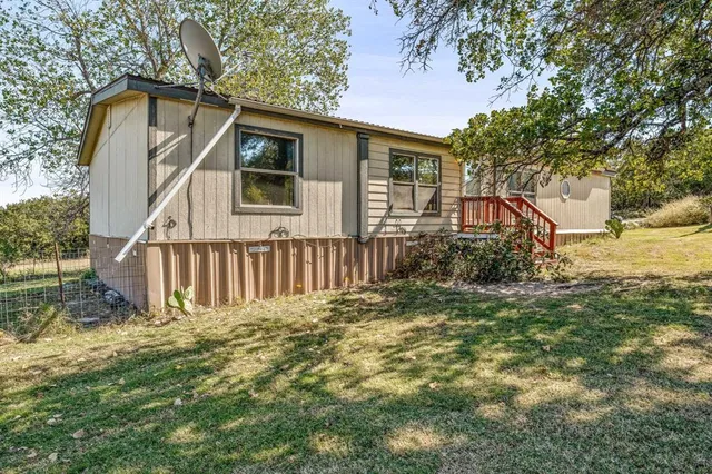 a view of a house with a small yard and wooden fence