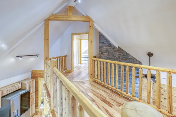 a view of a hallway with wooden floor and staircase